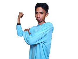 excité asiatique homme portant bleu T-shirt montrant fort mouvement élevage bras blanc Contexte. photo