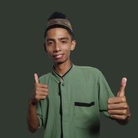 asiatique homme souriant visage avec d'accord geste, isolé sur vert Contexte photo