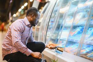 homme achats pour poisson Fruit de mer dans supermarché vente au détail boutique photo