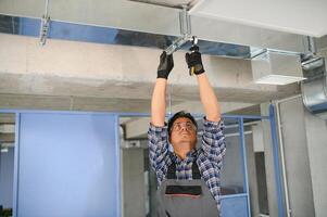 HVAC Indien ouvrier installer canalisé tuyau système pour ventilation et air conditionnement. copie espace photo