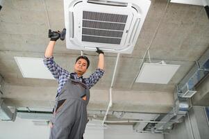 concentré Jeune Indien ingénieur réglage en haut air Conditionneur. photo