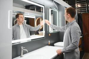 homme choisir Nouveau salle de bains meubles à le plomberie magasin avec beaucoup de sanitaire des biens photo