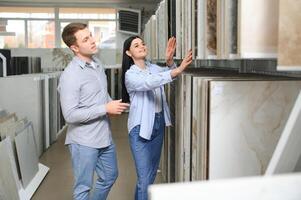 magnifique Jeune couple choisir céramique carrelage pour leur maison réparation dans le bâtiment magasin photo