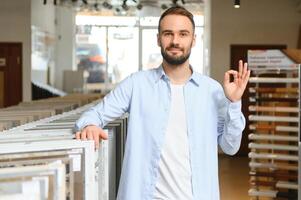 homme choisir carrelage à bâtiment marché photo