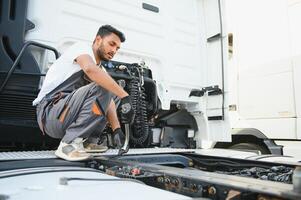 homme dans uniforme. un camion réparation. voiture mauvais fonctionnement photo