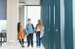 portrait de des gamins permanent dans élémentaire école couloir photo