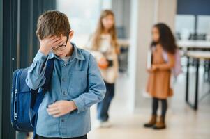 école copains harcèlement une triste garçon dans couloir à école photo