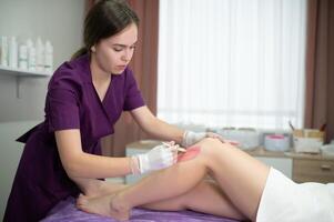 esthéticien fartage femme jambes dans une spa salon photo
