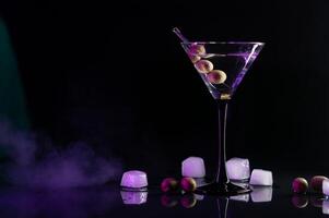 martini cocktail boisson éclaboussure avec la glace cubes dans néon iridescent rose et bleu couleurs. minimal nuit fête la vie concept. photo