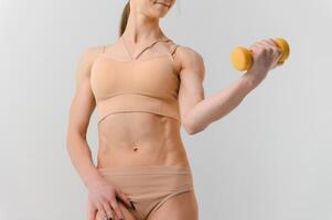 svelte aptitude modèle sur une blanc Contexte. parfait forme de le femelle corps. sport, santé et régime concept. photo