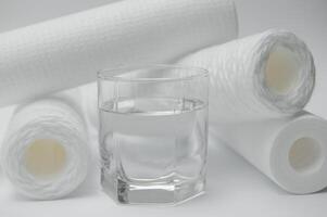 une verre de boisson l'eau et filtre cartouches à blanc Contexte photo