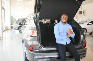 Beau homme est permanent près le sien Nouveau voiture et souriant photo