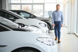 Jeune homme achat premier électrique voiture dans le salle d'exposition. éco voiture vente concept photo