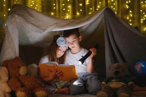 peu les enfants en train de lire heure du coucher récit à maison. photo