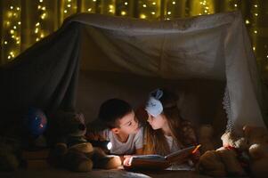 peu les enfants en train de lire heure du coucher récit à maison. photo