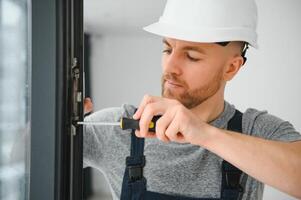 professionnel Maître à réparation et installation de les fenêtres, à travail. photo