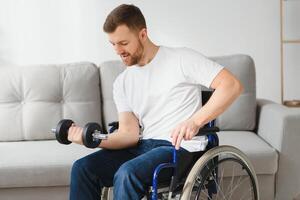 sportif séance dans fauteuil roulant et s'étirer bras avec haltères pendant réhabilitation exercice dans moderne médical centre. photo