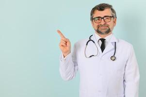 professionnel médecin homme dans blanc uniforme posant sur bleu studio Contexte. panorama avec copie espace. photo