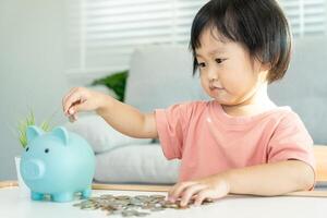 économiser de l'argent. les enfants mettent des pièces pour économiser. richesse, finance, assurance, investissement, éducation, avenir, planifier la vie, apprendre, banque, famille, santé, assurance maladie et accident. photo