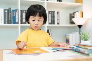 content asiatique les enfants se détendre lis livre à maison. fille et en train de lire une histoire. apprendre développement, garde d'enfants, en riant, éducation, narration, pratique, imaginer, réduire dépendance mobile téléphone photo