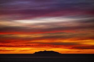 une spectaculaire le coucher du soleil avec île dans silhouette photo