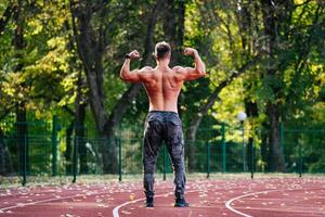 une fort homme montrant de le sien muscles photo