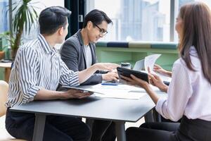 équipe de Jeune asiatique entrepreneur avoir petit équipe réunion pour A venir projet pour commercialisation et vente la gestion avec gratte-ciel vue pour affaires Commencez et éducation usage photo