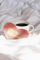 Fait main valentines cœur et café tasse sur lit. confortable la Saint-Valentin journée Matin. photo