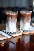 deux glacé moka café deux couches Frais Lait et Expresso court sur en bois table à café. photo