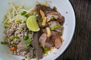 thaïlandais sec nouille avec haché porc, entrailles dans blanc bol céramique. photo