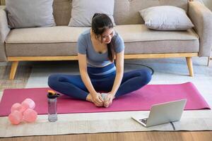 femmes sont élongation, à maison, et aptitude femmes exercice ou faire yoga dans leur chambre pour santé et bien-être une en bonne santé, calme femelle la personne formation ou travail sur le maison sol. photo