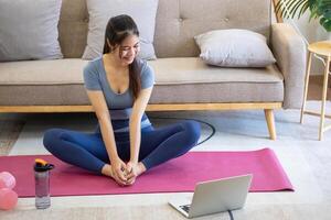 femmes sont élongation, à maison, et aptitude femmes exercice ou faire yoga dans leur chambre pour santé et bien-être une en bonne santé, calme femelle la personne formation ou travail sur le maison sol. photo