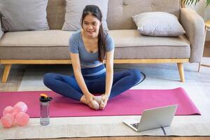 femmes sont élongation, à maison, et aptitude femmes exercice ou faire yoga dans leur chambre pour santé et bien-être une en bonne santé, calme femelle la personne formation ou travail sur le maison sol. photo