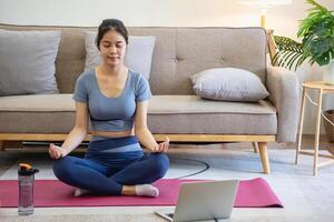 en bonne santé Jeune femme Faire respiration des exercices à maison, magnifique femme méditer à Accueil avec yeux fermé, pratiquant yoga, Faire pranayama techniques pleine conscience méditation concept photo