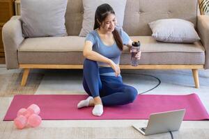 femmes sont élongation, à maison, et aptitude femmes exercice ou faire yoga dans leur chambre pour santé et bien-être une en bonne santé, calme femelle la personne formation ou travail sur le maison sol. photo