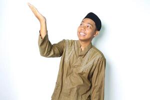 content asiatique musulman homme portant koko vêtements en présentant à au dessus avec ouvert paumes isolé sur blanc Contexte photo