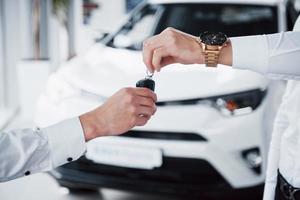 directeur des ventes en costume vendant la voiture au client. photo