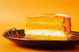 Gâteau au chocolat et à la crème à l'orange sur une assiette sur la table photo