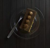 truffe gâteau sur verre assiette sur foncé en bois tableau. photo