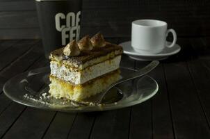 une pièce de truffe gâteau sur verre assiette sur foncé en bois tableau. photo