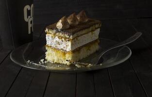 truffe gâteau sur verre assiette sur foncé en bois tableau. photo