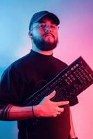 Jeune Latin américain homme avec barbe et des lunettes en portant une jeu clavier. photo