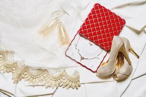 une mariage robe, des chaussures et accessoires sur une blanc tissu photo