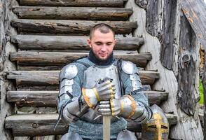 Chevalier dans le armure sur le en bois pas. chevaleresque armure et arme photo