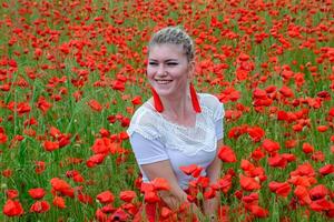 fille Sam dans le milieu de une coquelicot champ. photo