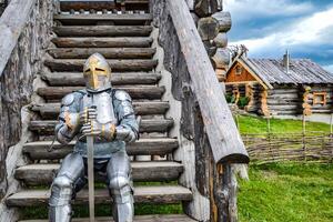 Chevalier dans le armure sur le en bois pas. chevaleresque armure et arme photo