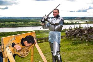 dramatisation peine dans le milieu âge. Chevalier balancé le sien épée à le prisonnier. photo