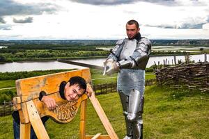 dramatisation peine dans le milieu âge. Chevalier balancé le sien épée à le prisonnier. photo