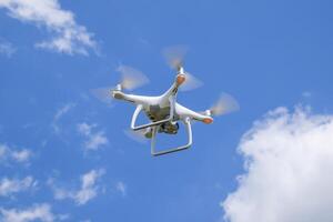 drone dji fantôme 4 dans vol. quadricoptère contre le bleu ciel avec blanc des nuages. le vol de le copter dans le ciel. photo