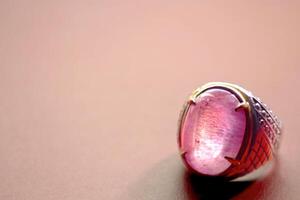 magnifique bague avec violet gemme isolé sur rose Contexte photo